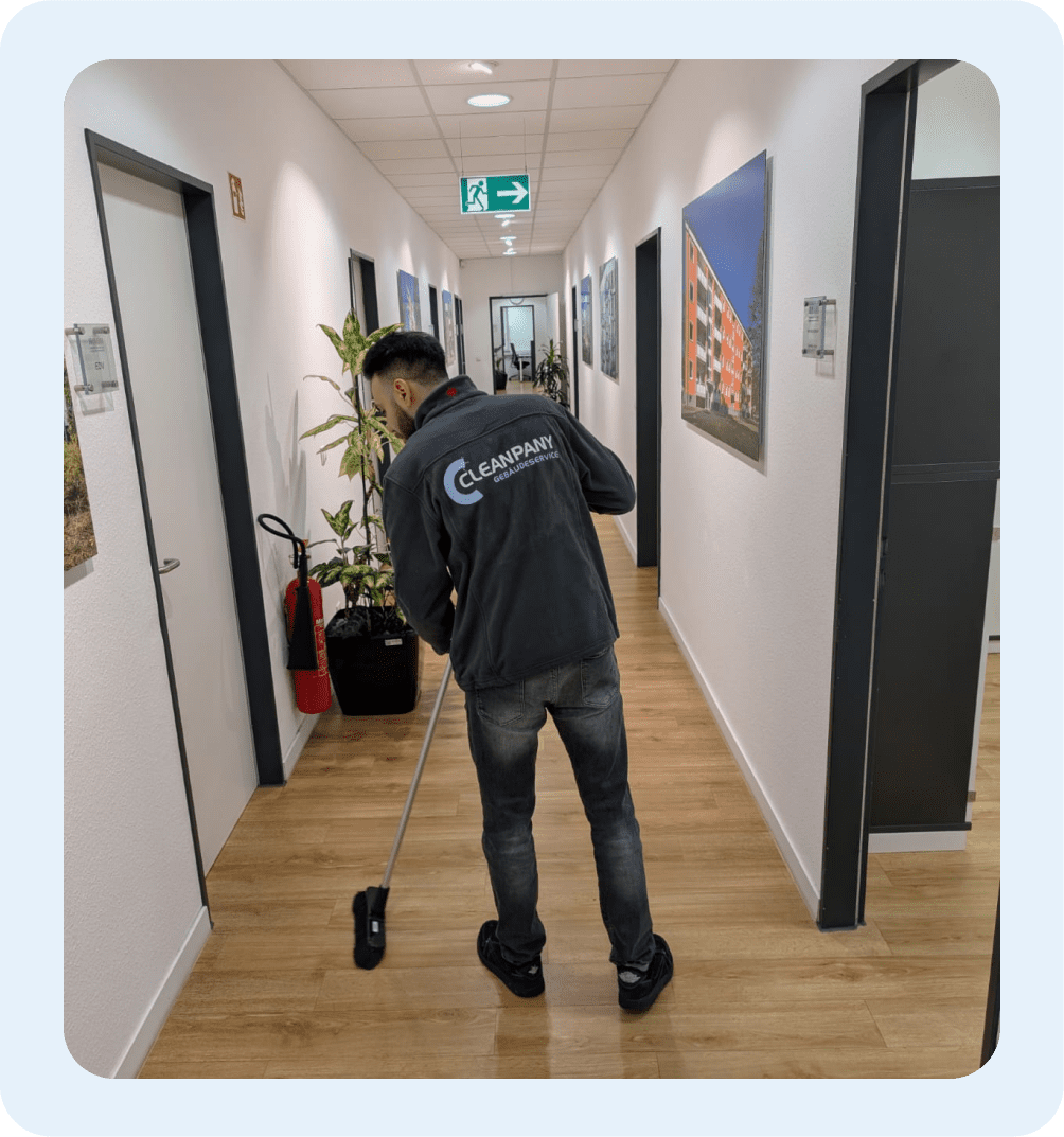 Mitarbeiter bei der Flurreinigung in einem modernen Geschäftsgebäude.